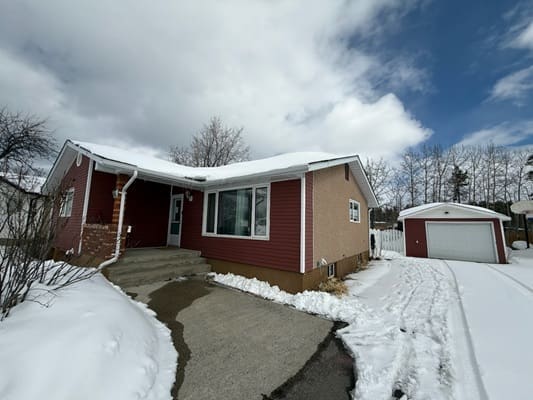 Snow-covered house with detached garage.