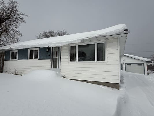 House covered in snow during winter storm.
