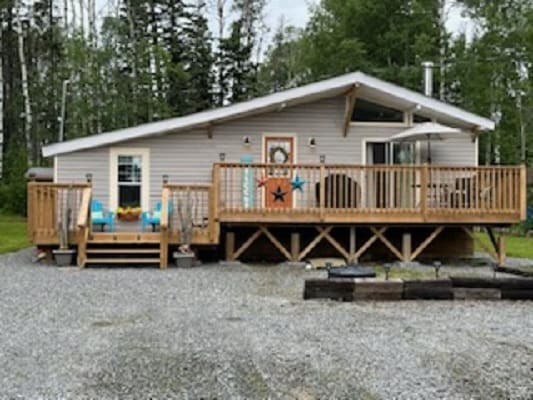 House with wooden deck and forest background.