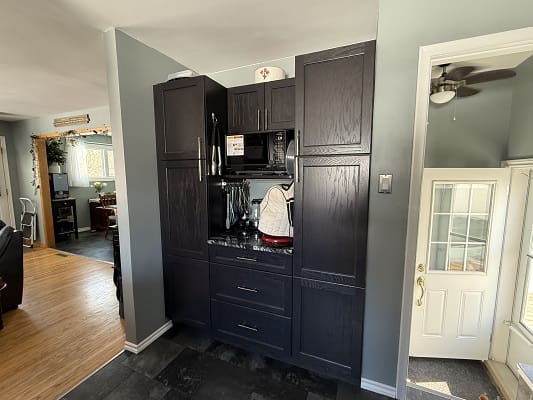 Dark kitchen cabinets with appliances and door.