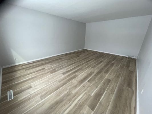 Empty room with wooden flooring and walls.