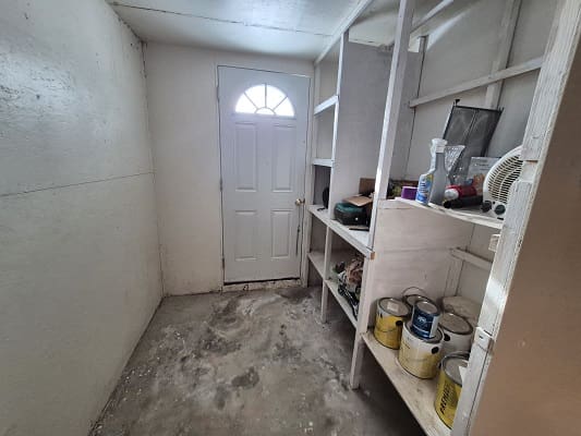Storage room with shelves and white door.
