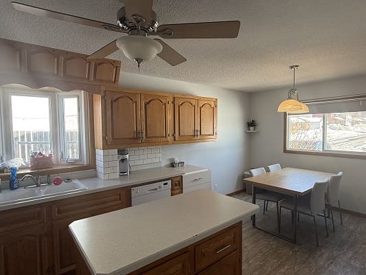 Kitchen with wooden cabinets and dining table.