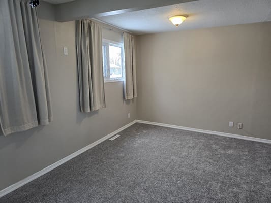 Empty room with carpet and curtains.