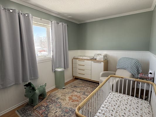 Nursery room with crib and dresser.