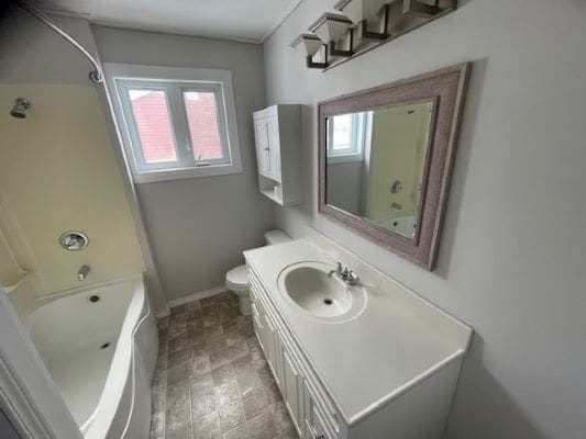 Small bathroom with shower and vanity.