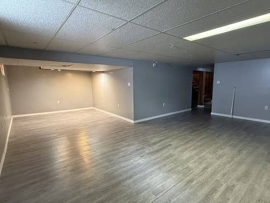 Spacious empty room with gray flooring.