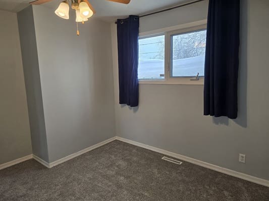 Empty room with window and blue curtains.