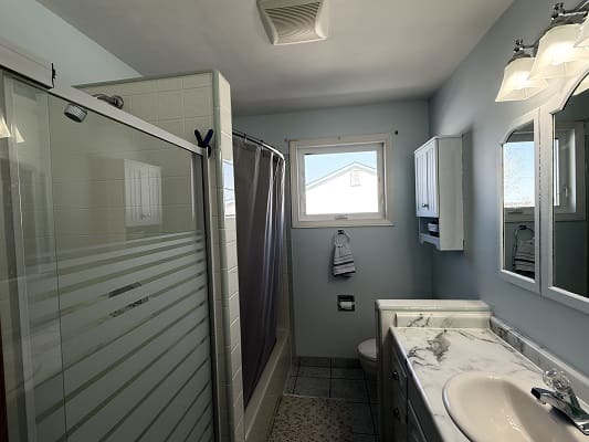 Modern bathroom with shower and marble sink.