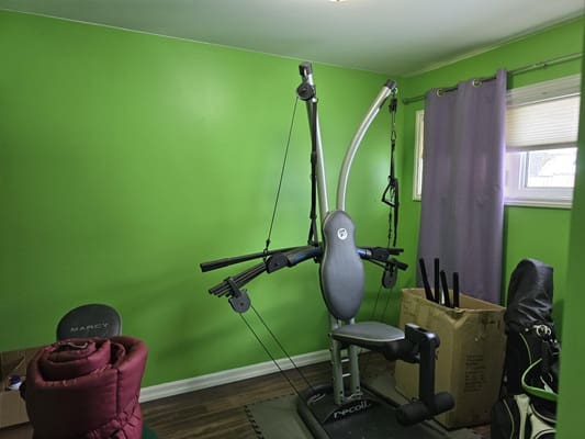 Home gym with exercise machine and equipment.