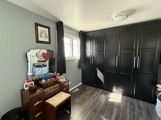 Bedroom with vanity and black wardrobes.