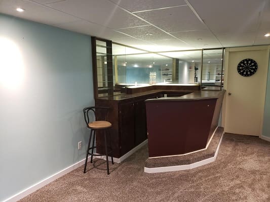 Basement bar with stool and dartboard.