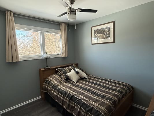 Bedroom with plaid bedding and wall art.