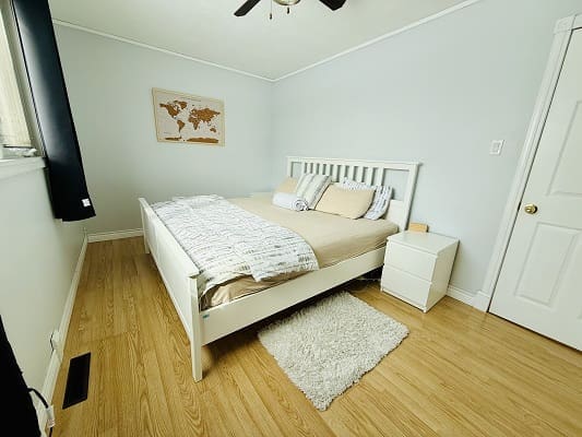 Minimalistic bedroom with bed and map decor.