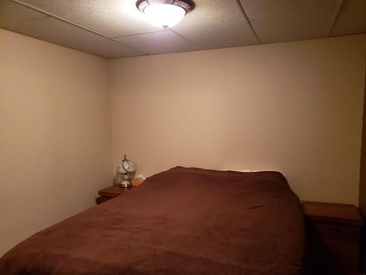 Bedroom with brown bedspread and nightstands.