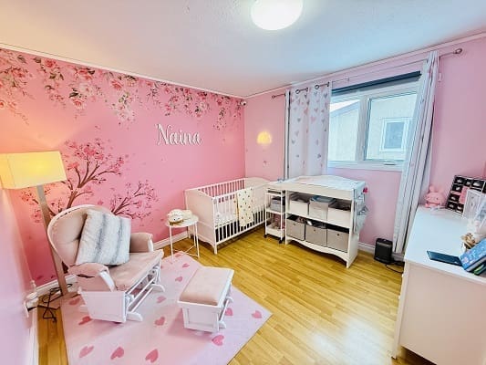 Pink nursery with crib and rocking chair.