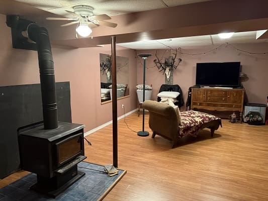Cozy basement with wood stove and TV.
