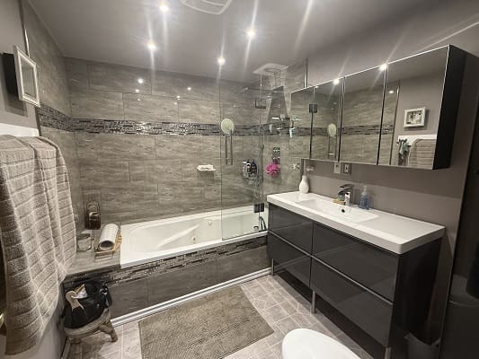 Modern bathroom with bathtub and vanity unit.