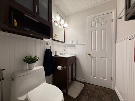 Small modern bathroom with white and dark accents.