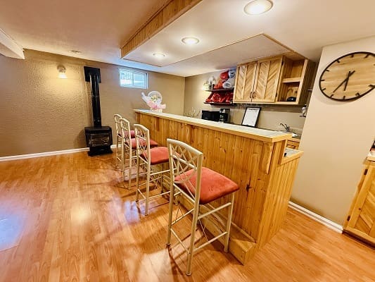 Home bar with stools and wall clock.