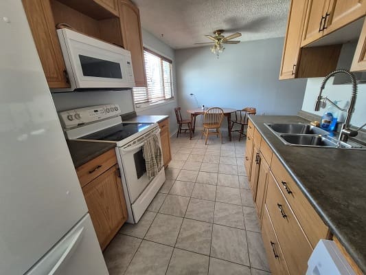 Galley kitchen with dining area and appliances.