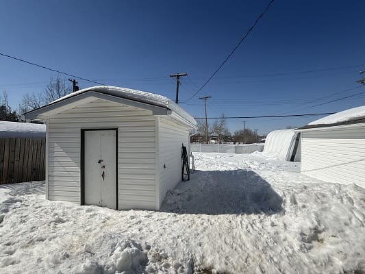 White shed surrounded by snow.