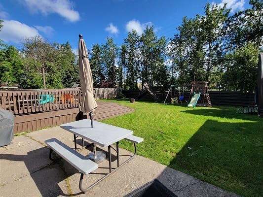 Backyard with picnic table and playground slide.