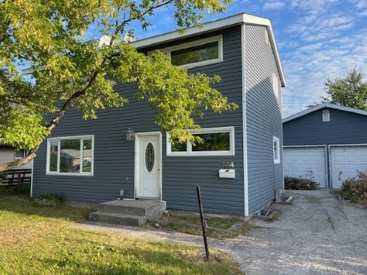 Modern blue house with white trim, driveway.