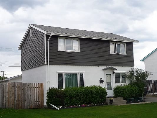Two-story house with dark upper siding.