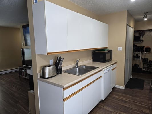 Modern kitchen with white cabinets and appliances.