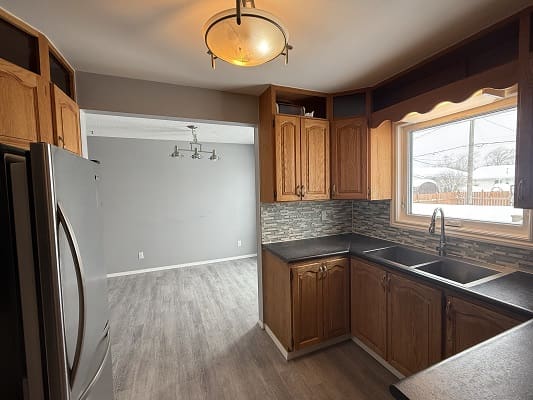 Modern kitchen with wooden cabinets and window.