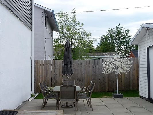 Backyard patio with table and chairs.