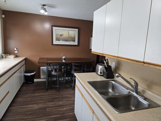 Modern kitchen with dining area and artwork.