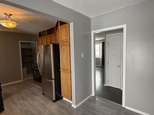 Kitchen area with stainless steel refrigerator, doorway.
