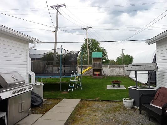 Backyard with trampoline and playground set.