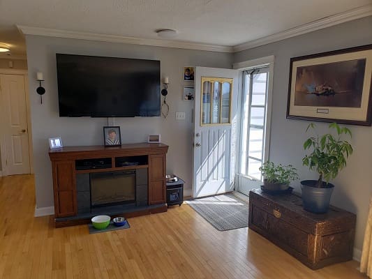 Living room with TV and open door.