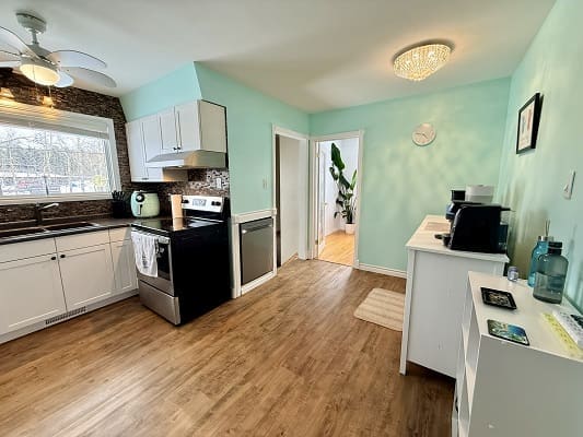 Bright kitchen with wooden flooring and appliances.