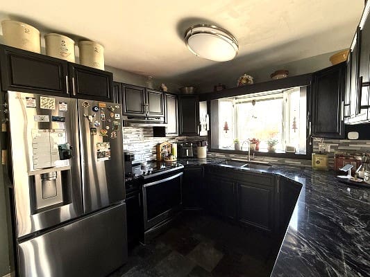 Modern kitchen with dark cabinets and appliances.