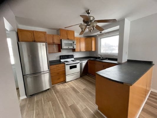 Modern kitchen with wooden cabinets and appliances.