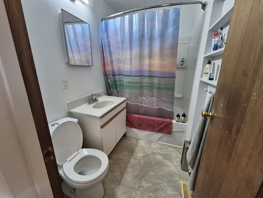 Bathroom with ocean-themed shower curtain.