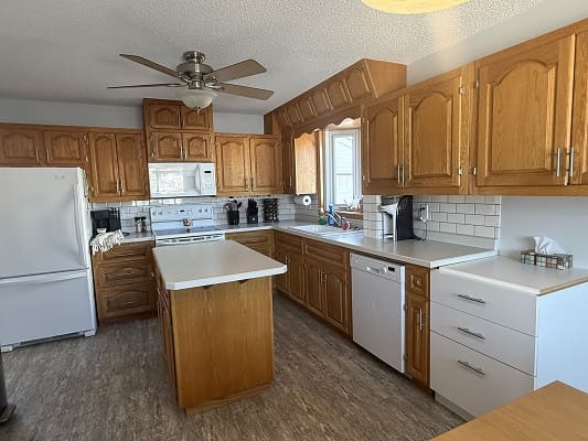 Spacious kitchen with wooden cabinets and island.