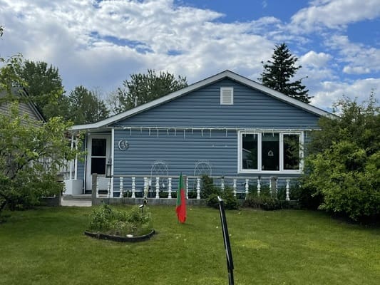 Blue bungalow with front garden and lawn